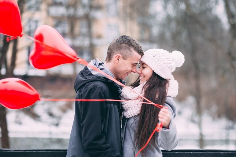 a woman and a man hugging face to face holding heart shaped balloons