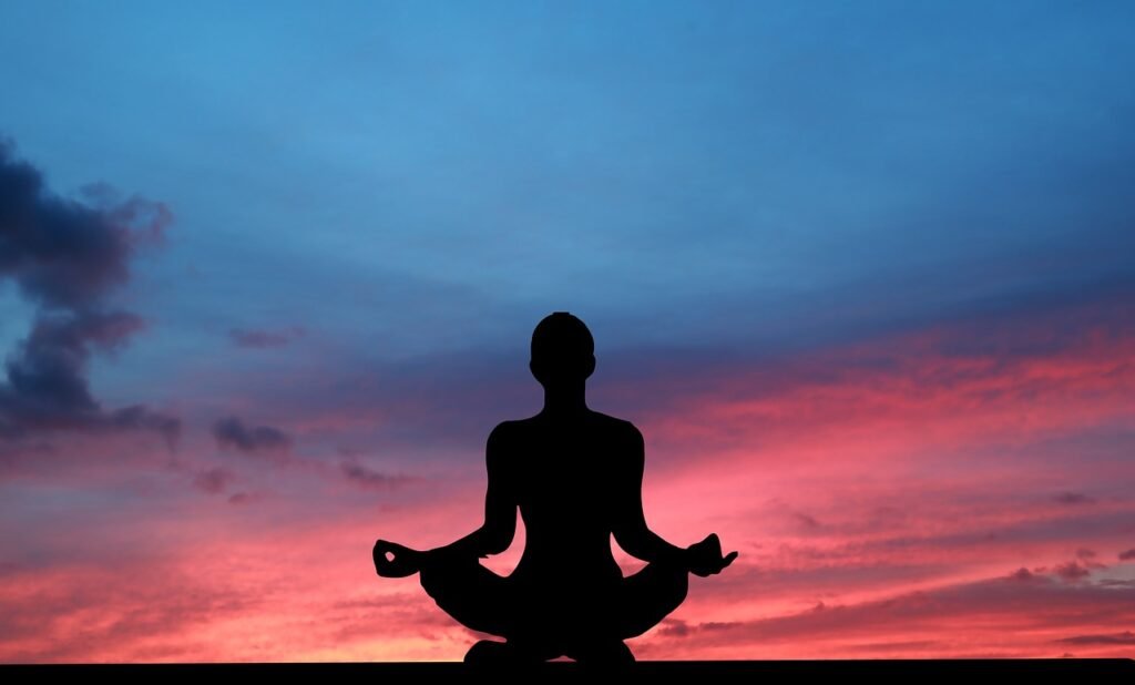 A woman sitting in a yoga position facing the sunset 4830931.