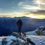 person standing on top of the mountain facing sunrise