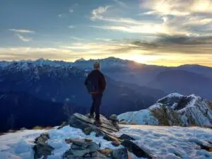 person standing on top of the mountain facing sunrise