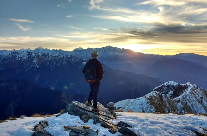 person standing on top of the mountain facing sunrise