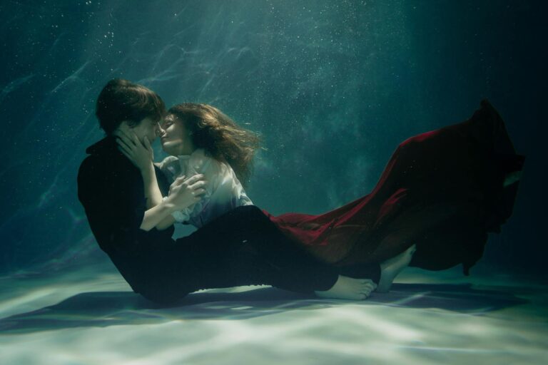 A couple embraces passionately underwater, creating a dreamy and romantic scene.