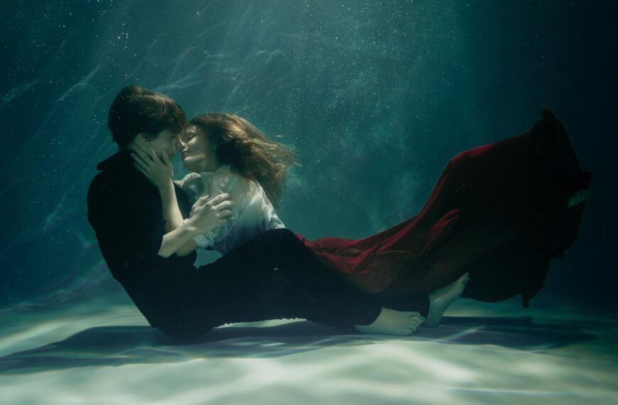 A couple embraces passionately underwater, creating a dreamy and romantic scene.