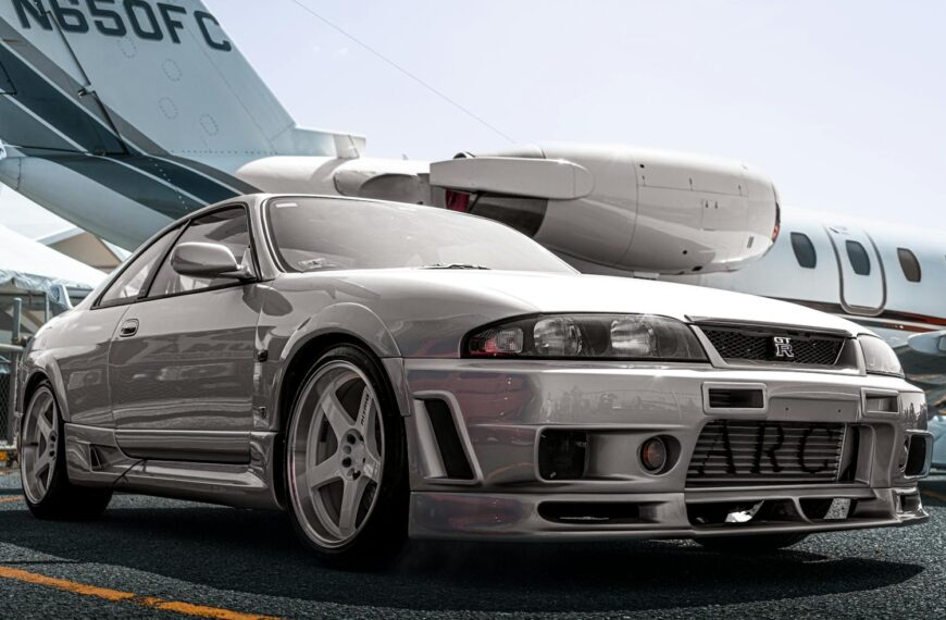 A silver sports car parked on the tarmac with a private jet in the background, all from visualization exercises