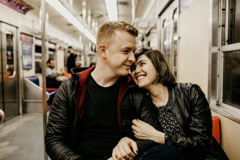 The young couple is sharing a tender moment together on a train journey.