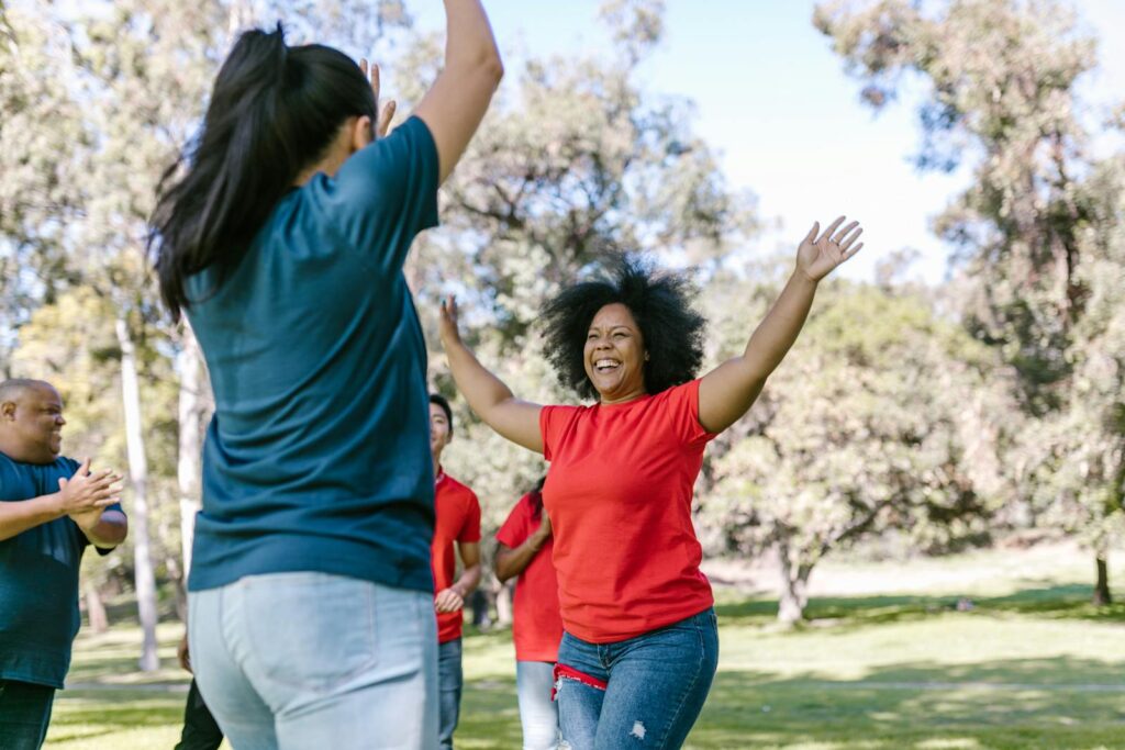 A diverse group of adults engaged in a lively outdoor team-building activity, fostering unity and enjoyment.