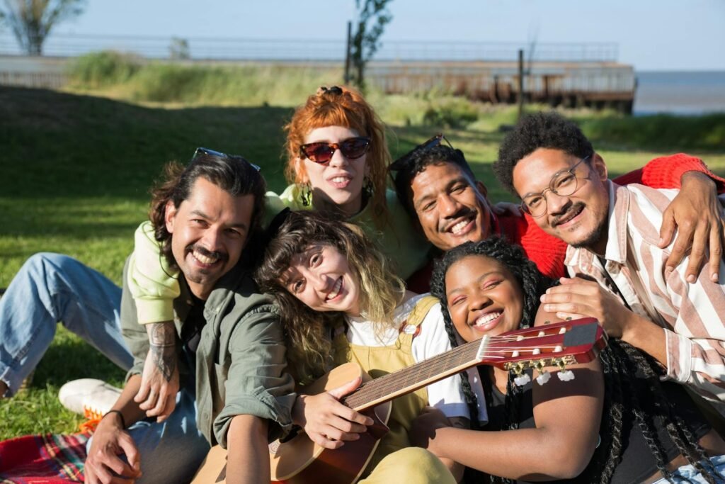 A diverse group of friends enjoying a sunny day outdoors with music and laughter.