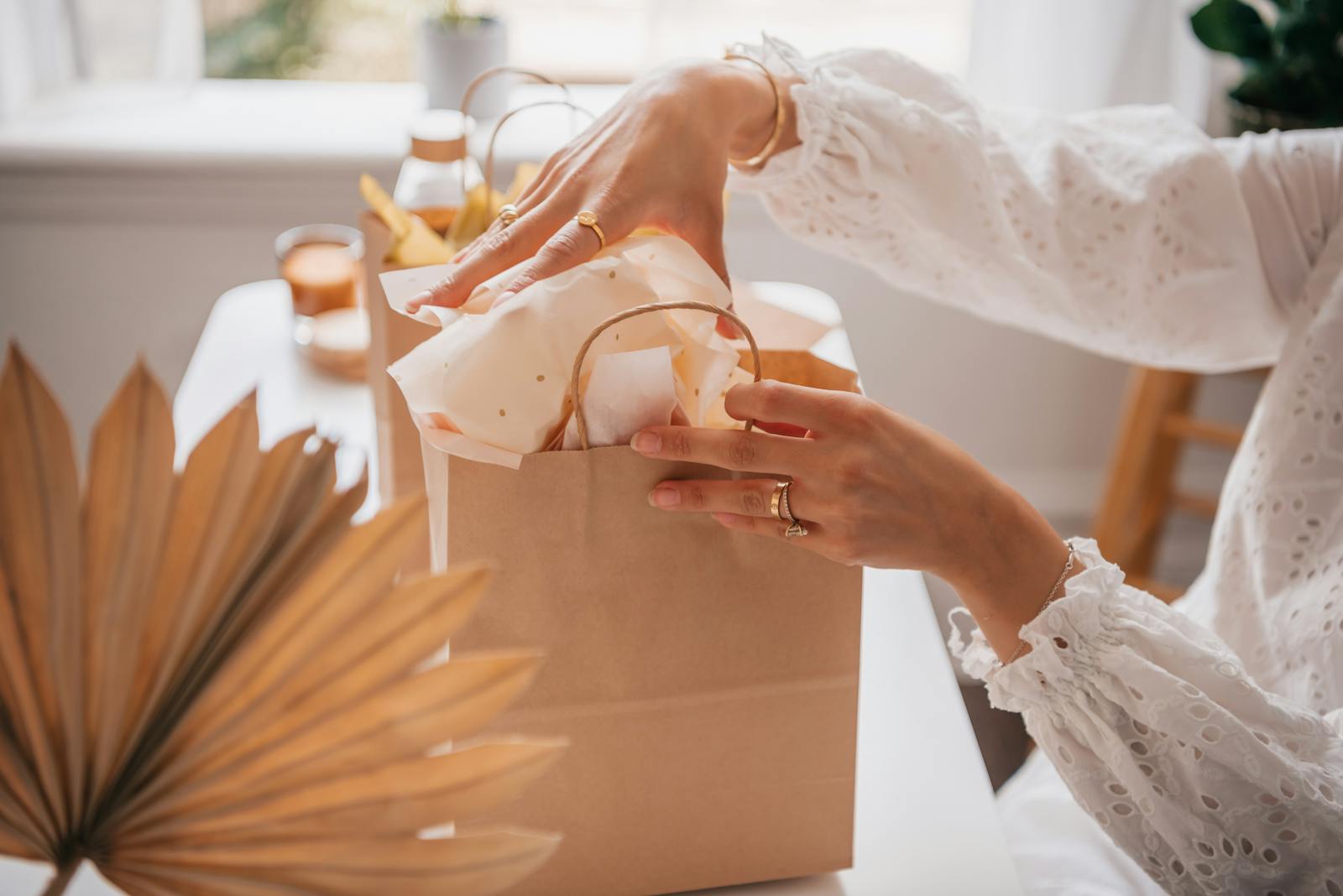 A woman opening a gift bag on a wooden table proves she can attract abundance